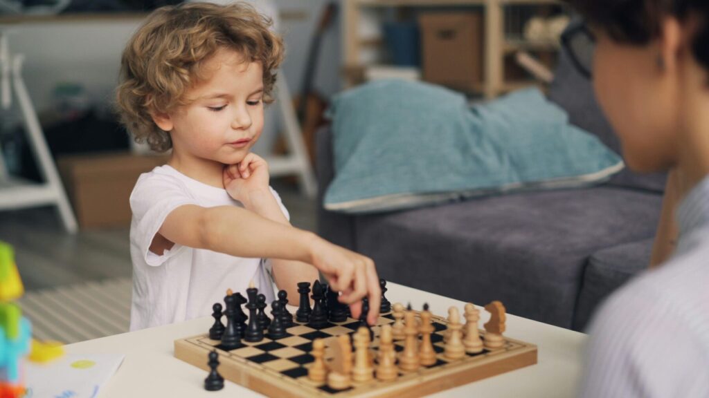 adult guiding child during chess game showing structured learning and feedback