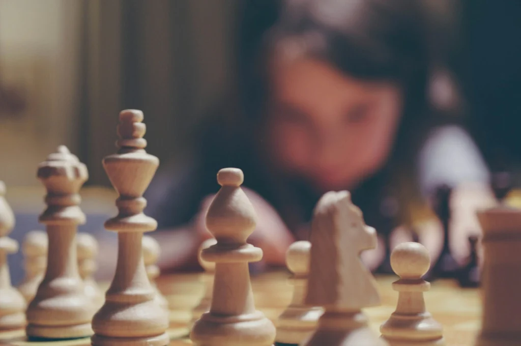 young child exploring chess pieces through play and visual learning